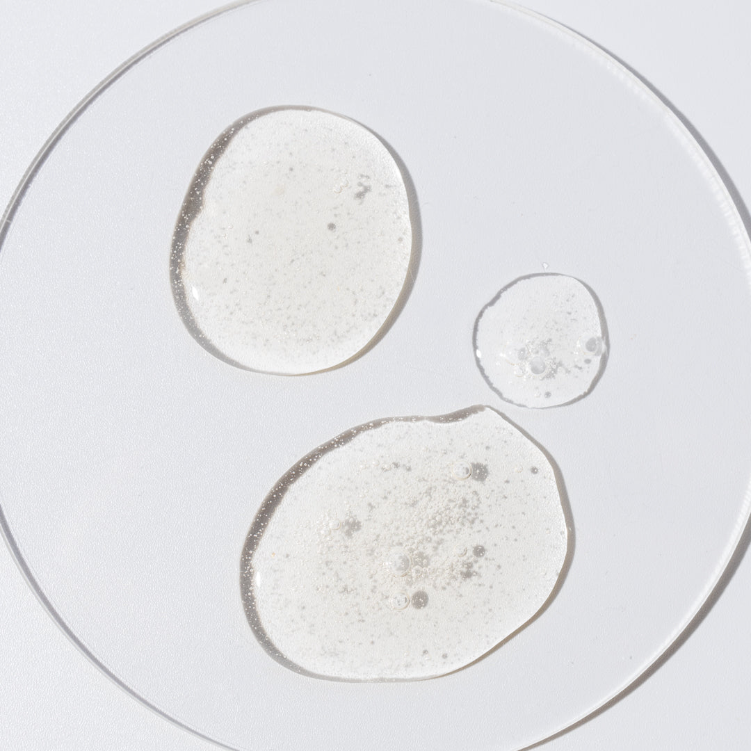 Picture of a facial serum over a glass petri dish