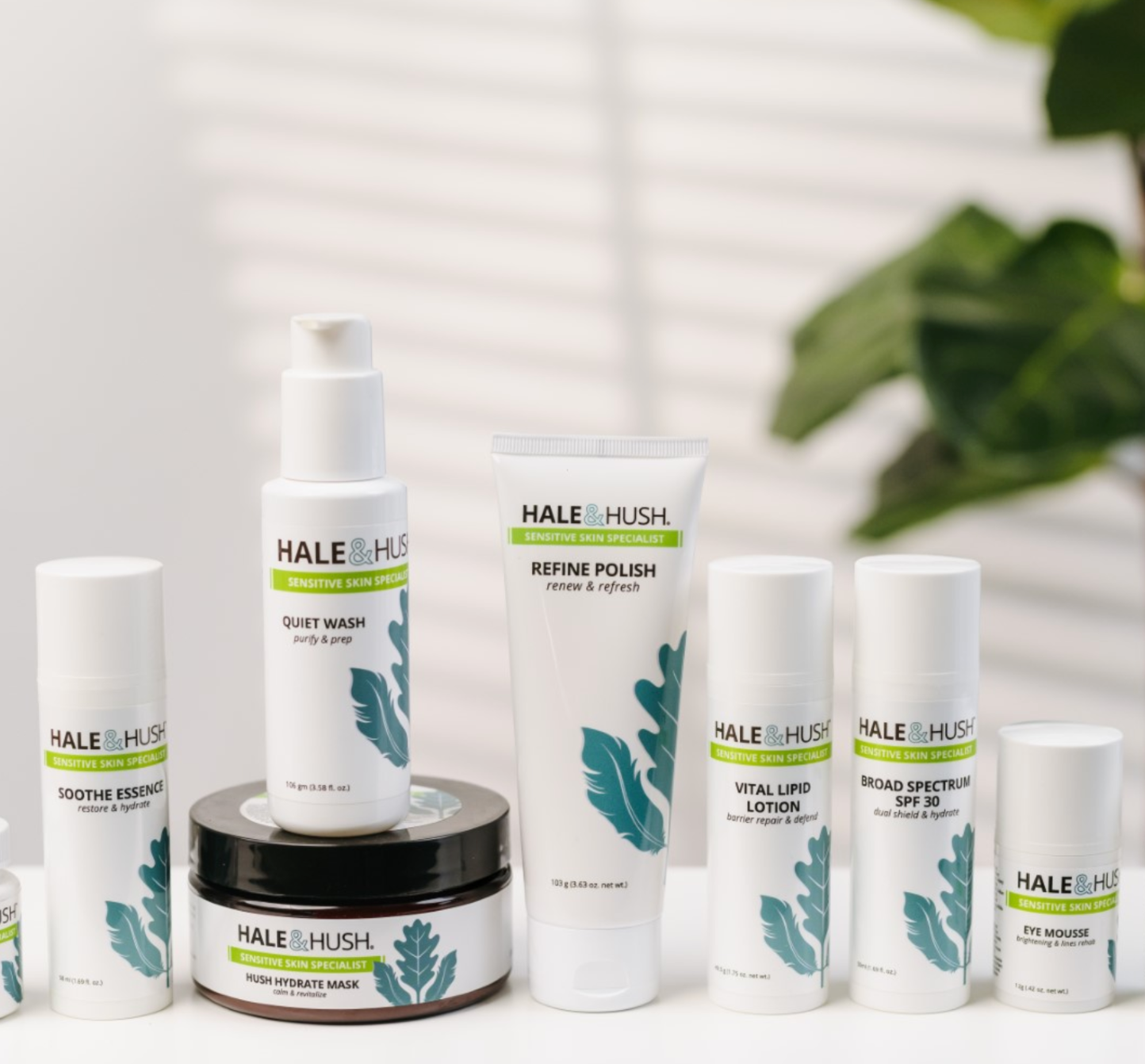 A collection of Hale & Hush skincare products with a plant and shadow background
