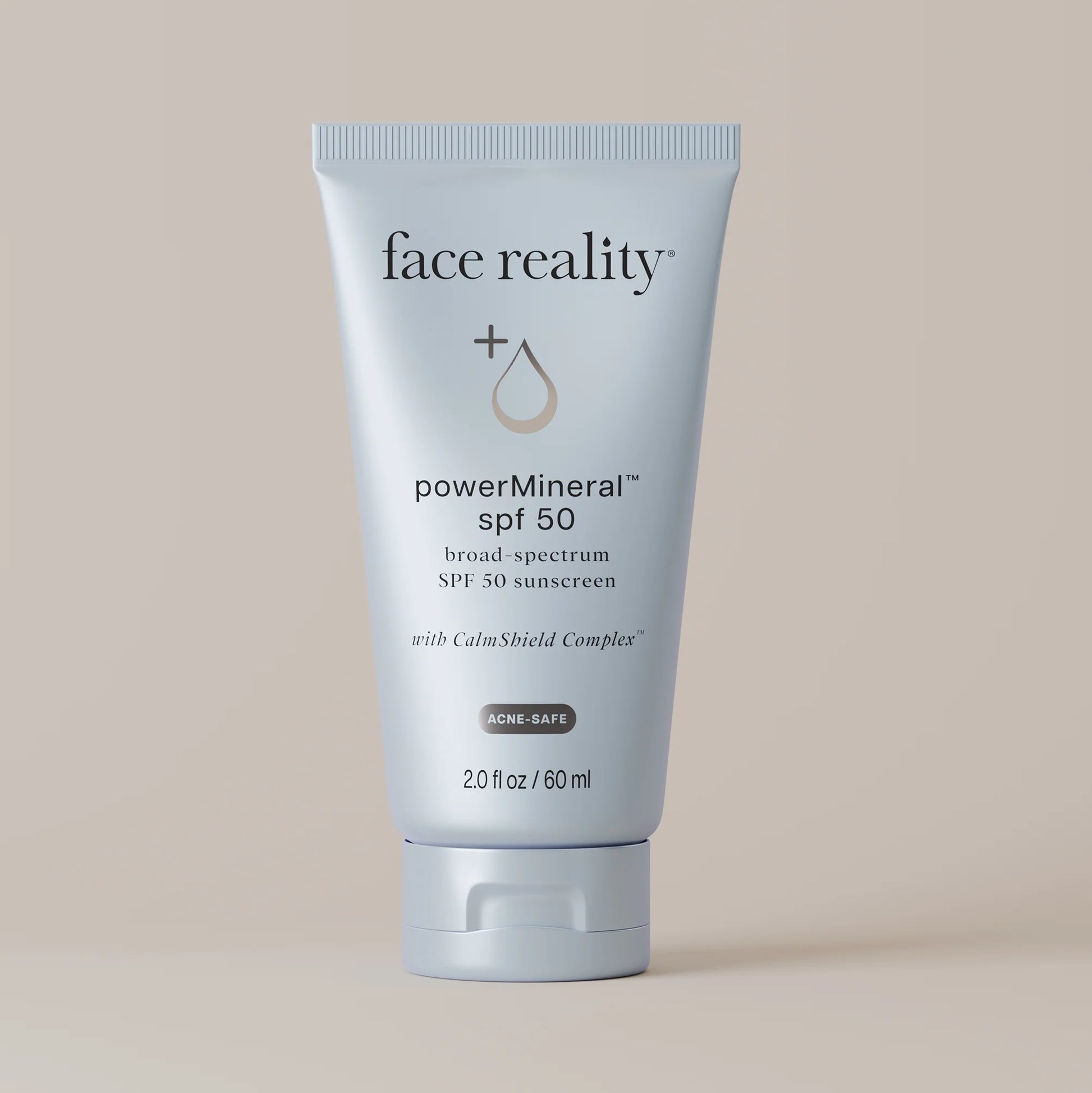 Tube of 'face reality' powerMineral SPF 50 sunscreen on a beige background