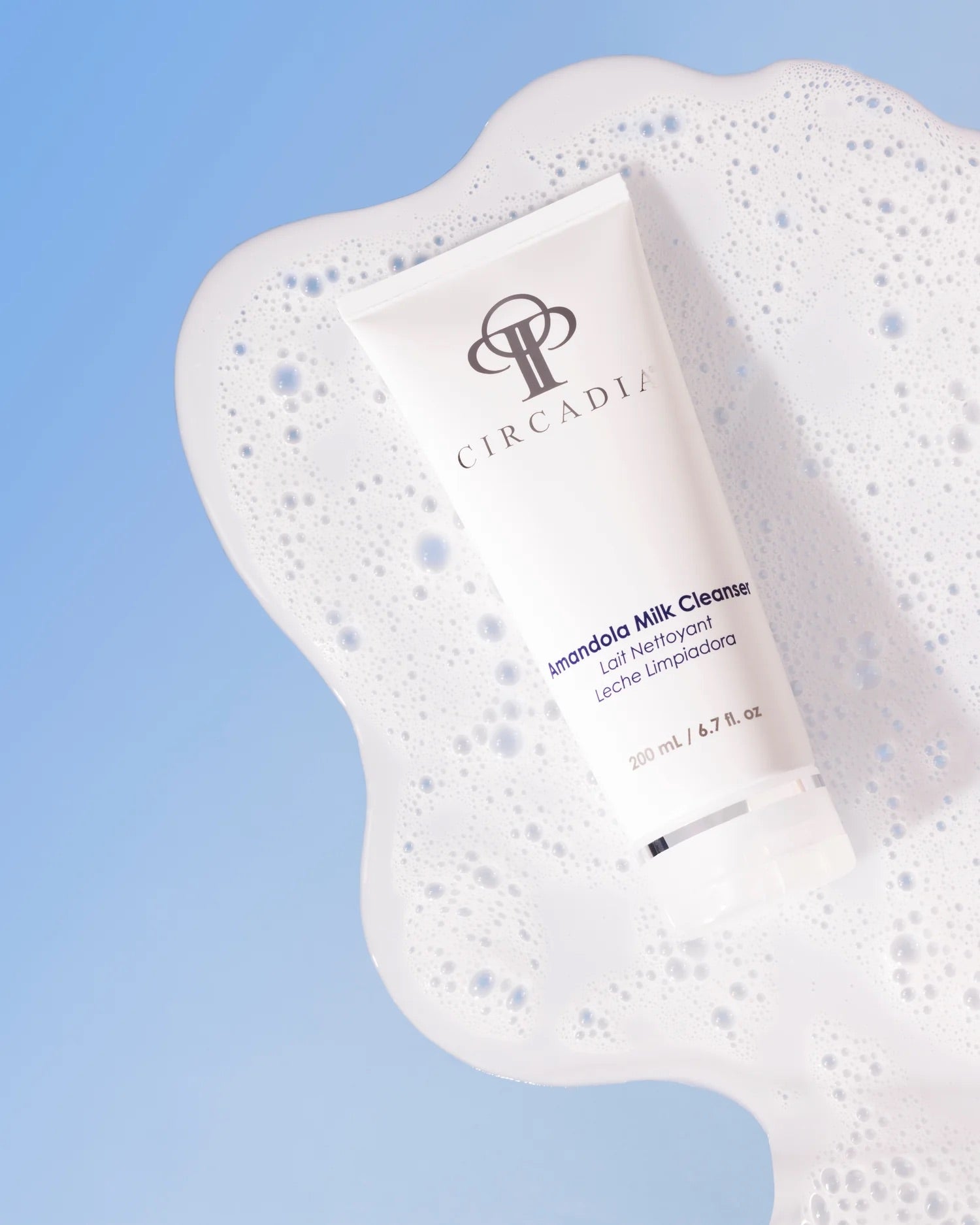 Circadia's Amandola Milk Cleanser laying on top of foaming product, against a light blue background