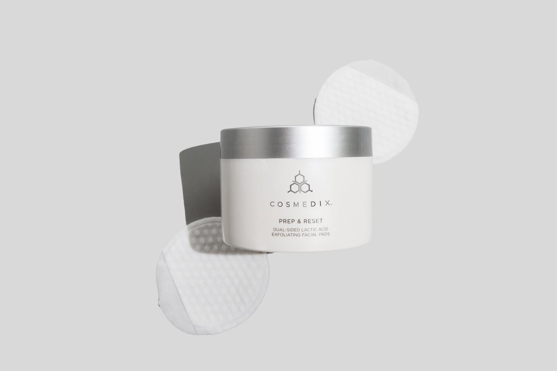 COSMEDIX'S Prep & Reset Dual-Sided Lactic Acid Exfoliating Facial Pads white colored container with two pads displayed against a light grey background
