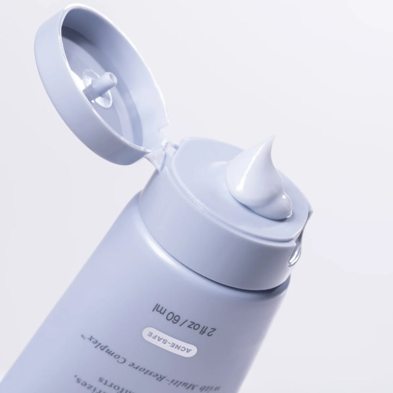 Zoomed in view of Face Reality's barrier care gel cream product tube, with cap open and product coming out of the tube.