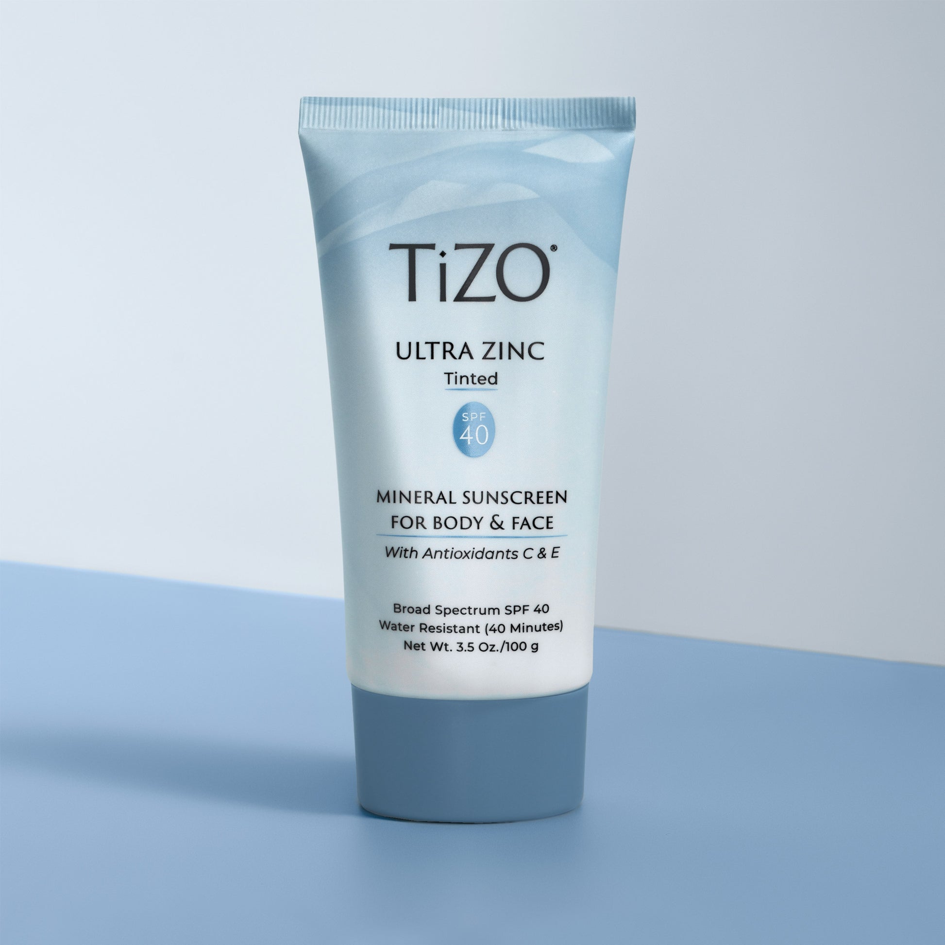 TiZO Ultra Zinc Body & Face - Tinted SPF 40 product tube on blue and white background
