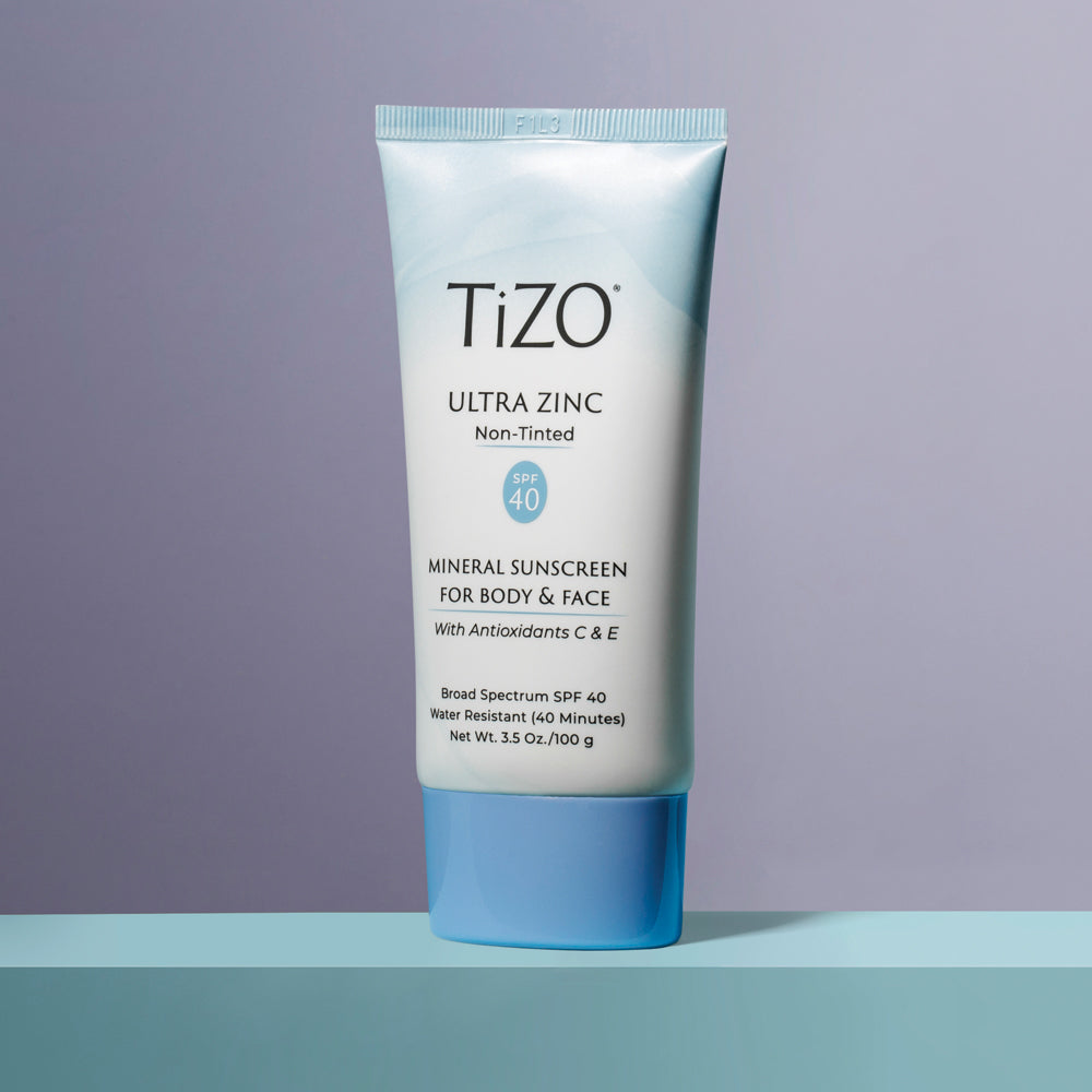 TiZO Ultra Zinc Body & Face - Non Tinted SPF 40 product tube standing on a blue ledge with grey background