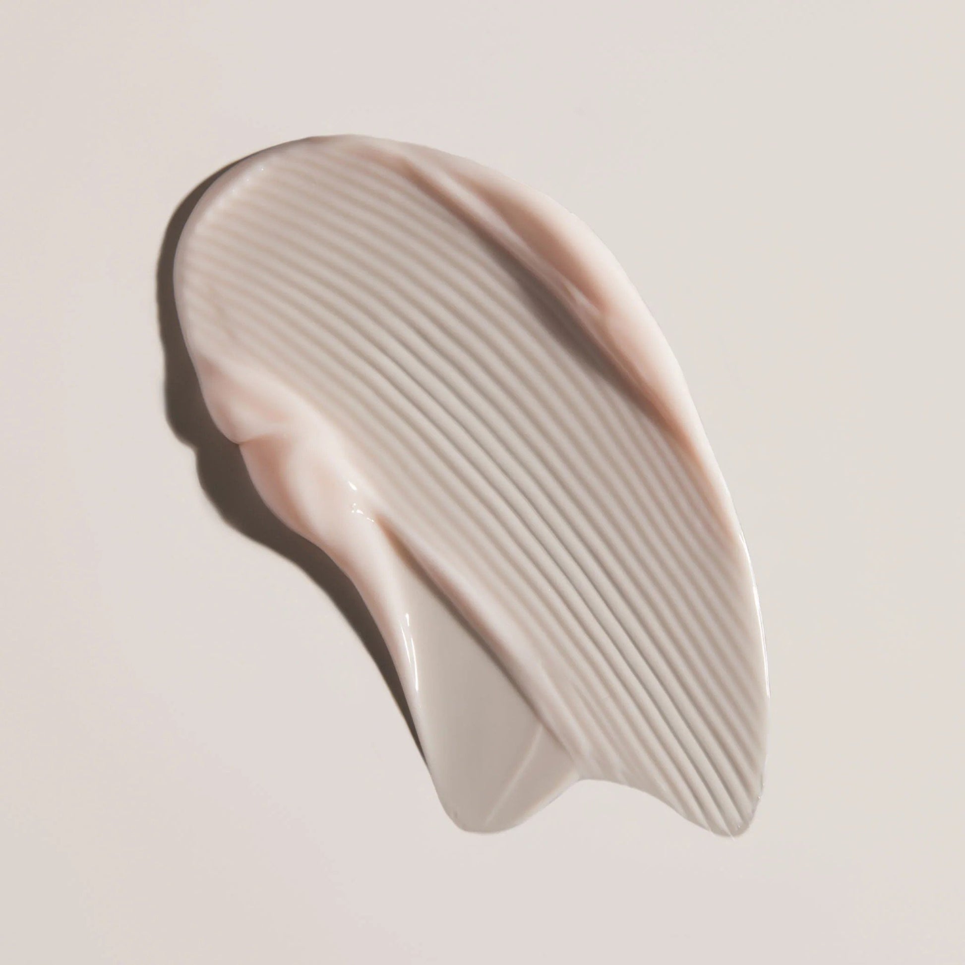 Face Reality's cran-peptide cream, beige colored product swatch against beige background