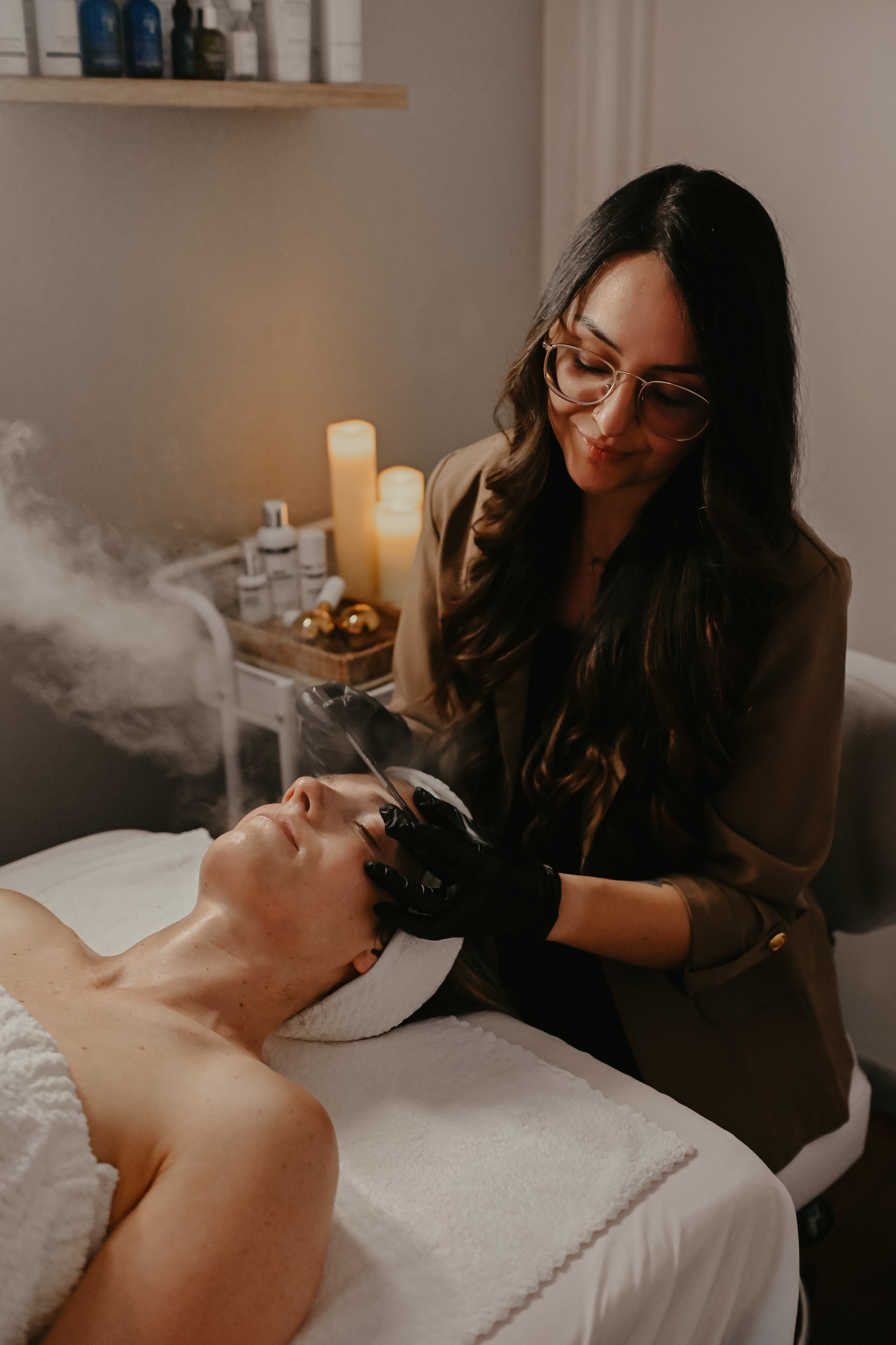 Woman receiving a dermaplane facial treatment from an esthetician in a spa setting at Luna Luxe Aesthetics