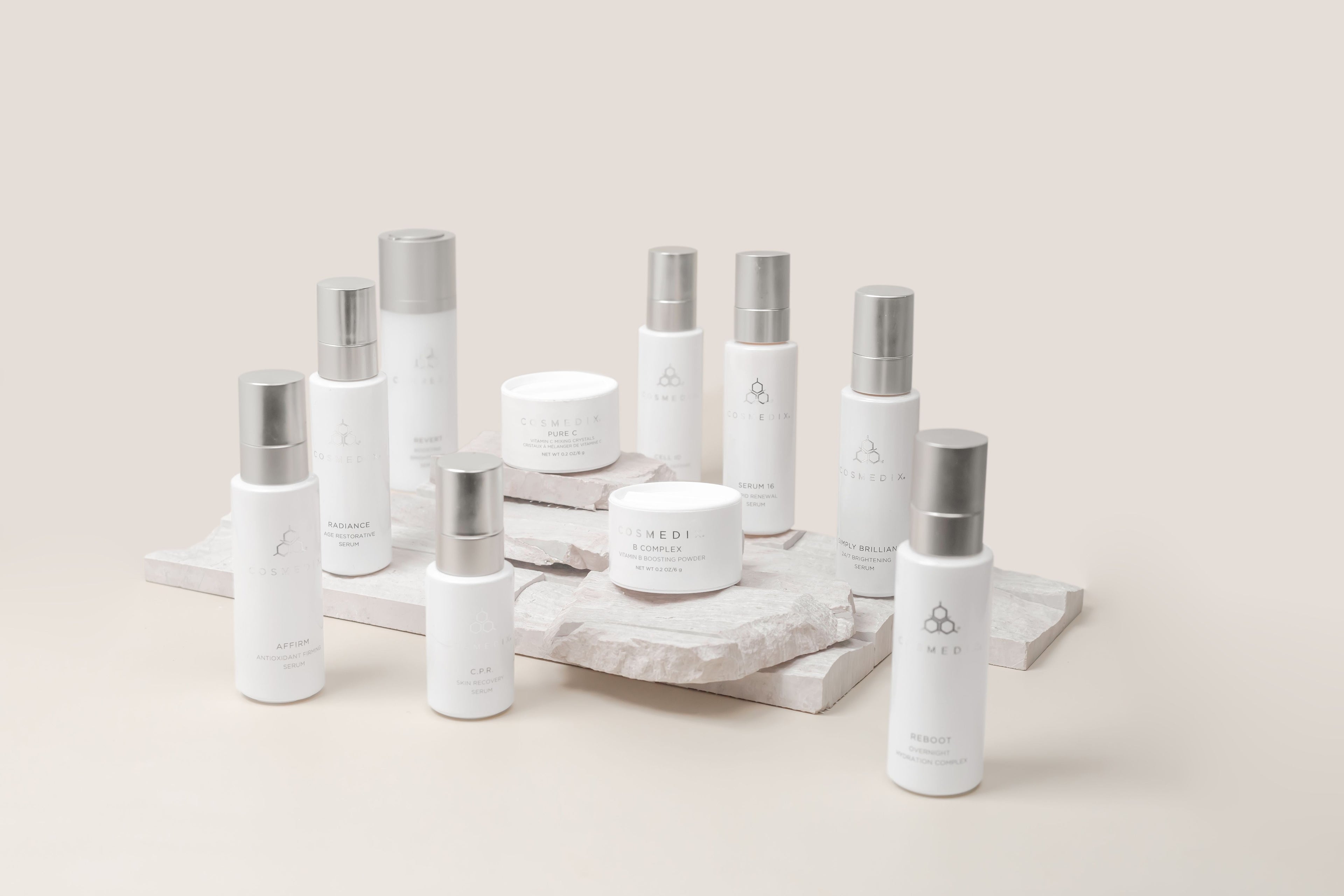Set of Cosmedix skincare products on a marble tray with a neutral background